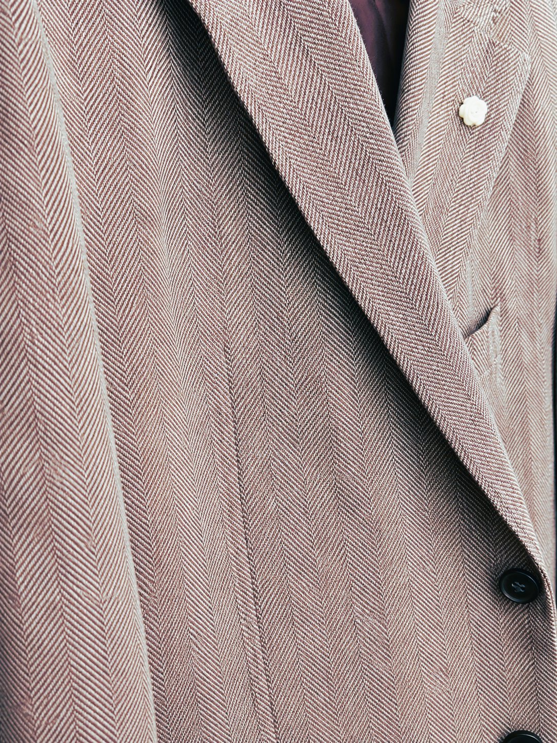 Close-up of a herringbone suit jacket lapel and buttons