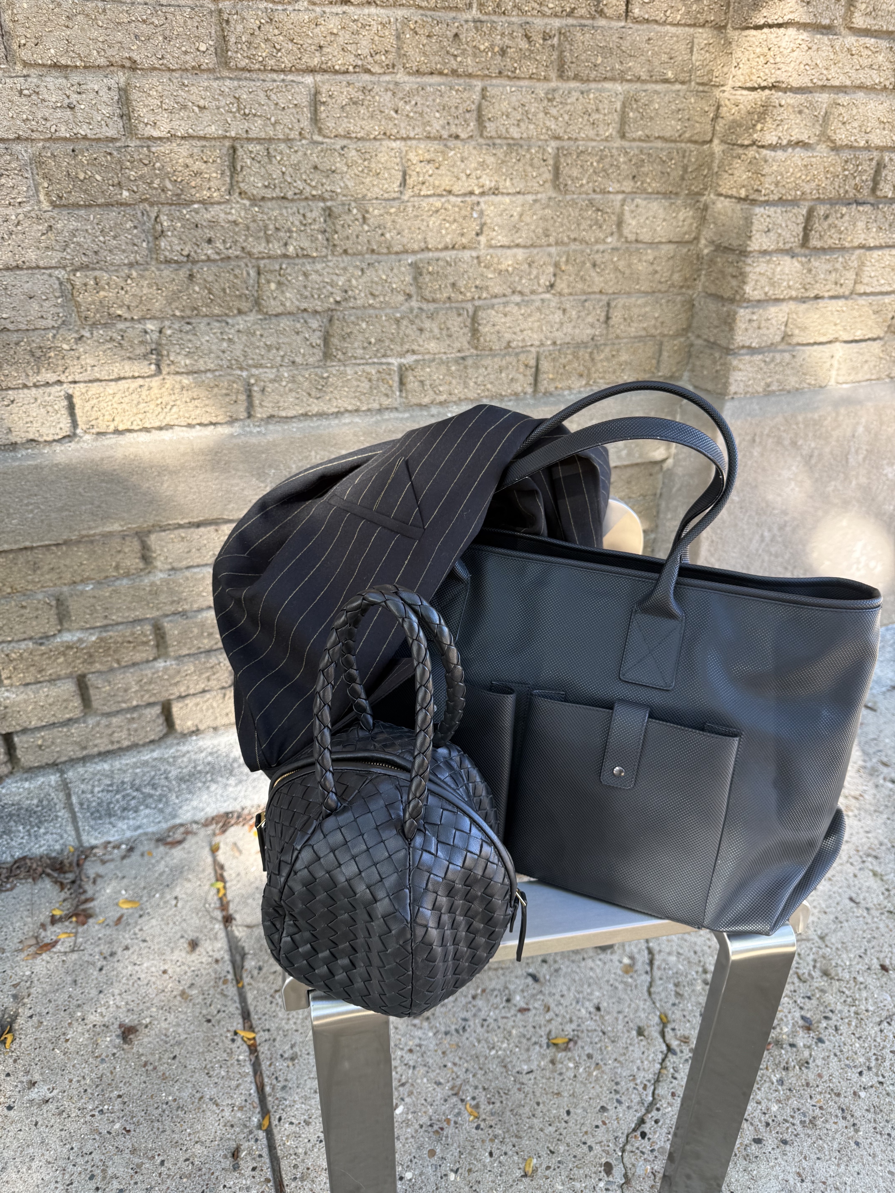 Black tote and small woven bag on the steel chair
