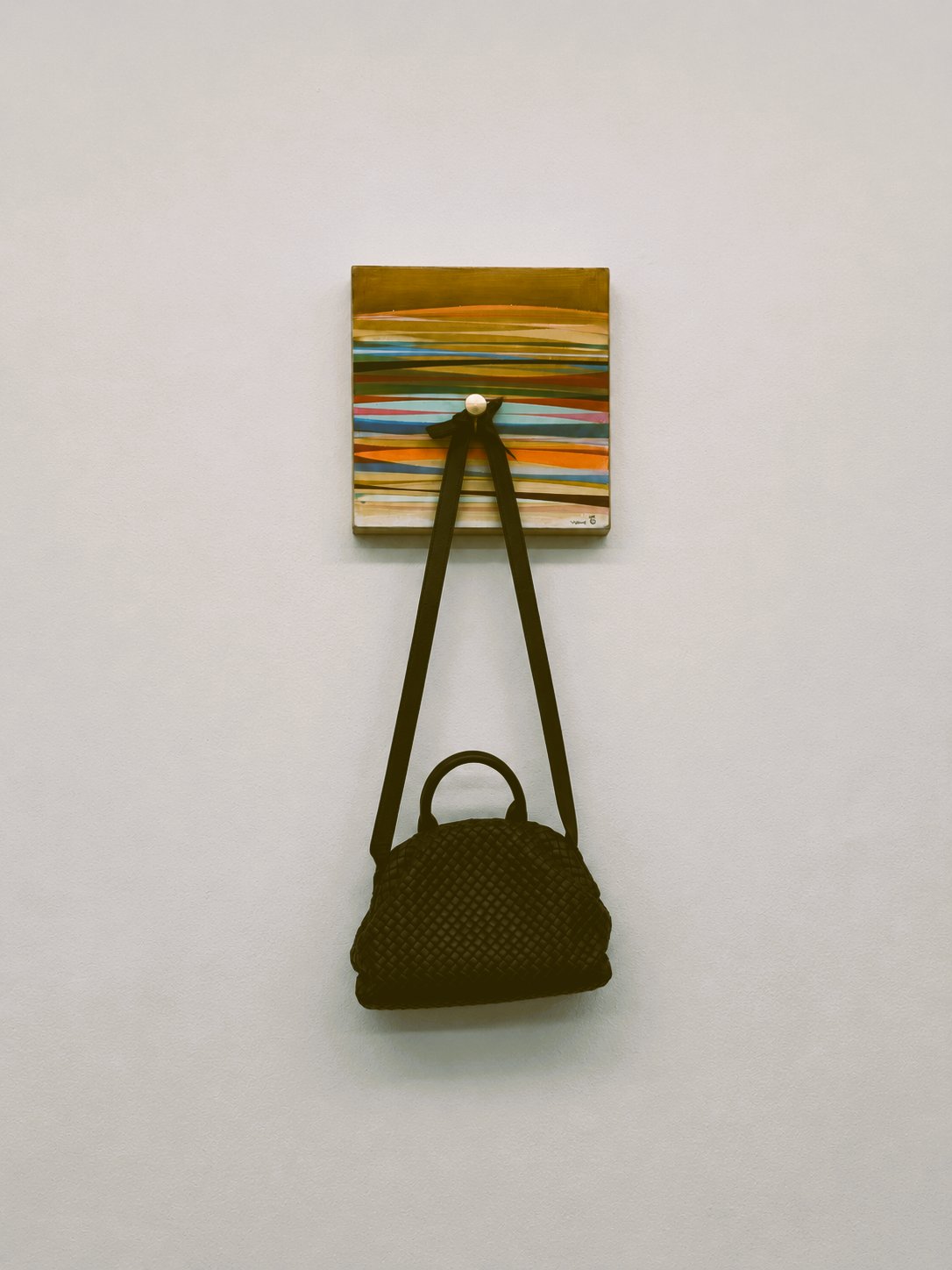 Chris Vance art piece with a Bottega Veneta bag hanging beneath it