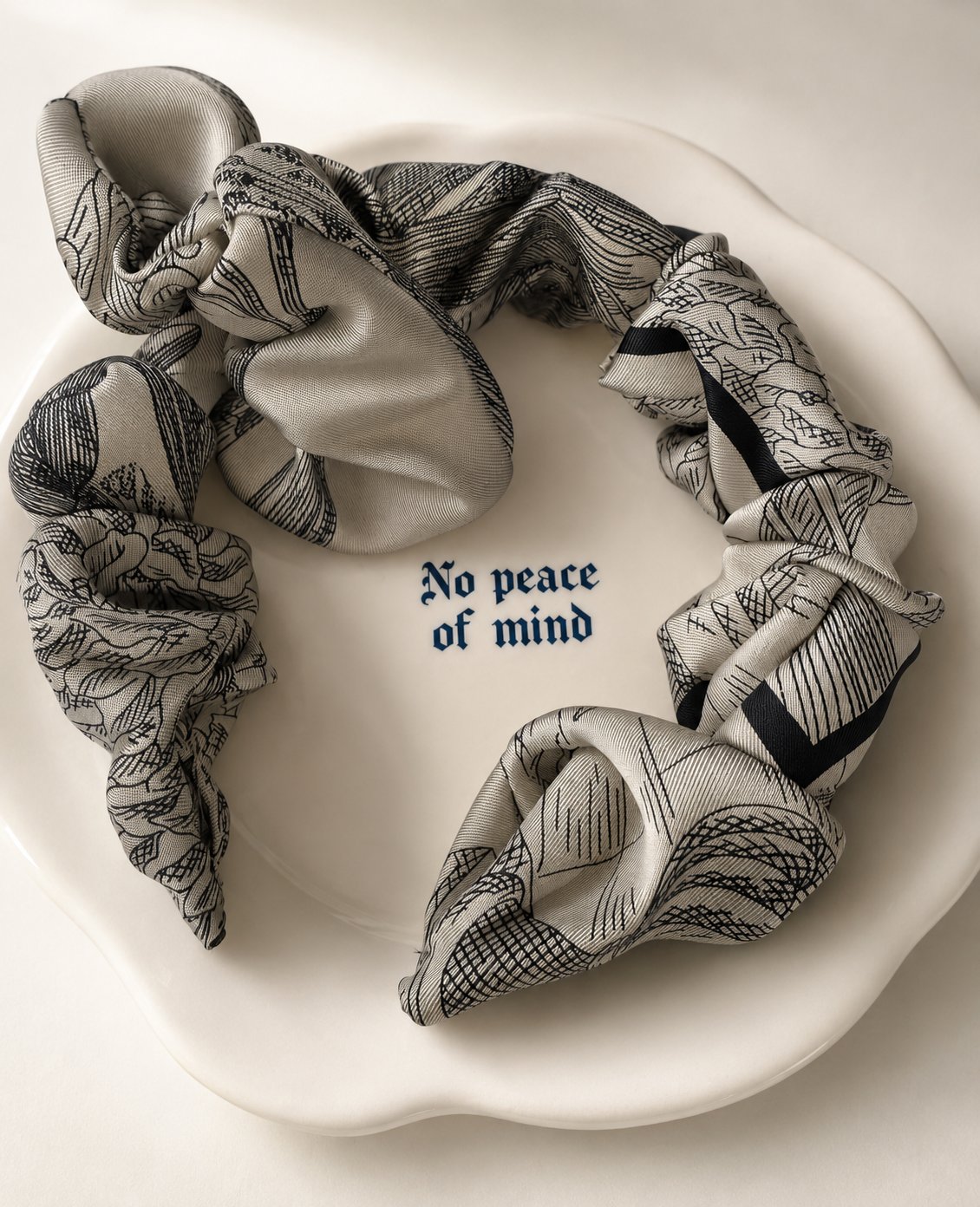 Christian Dior silk scarf tied into a hair accessory on a plate