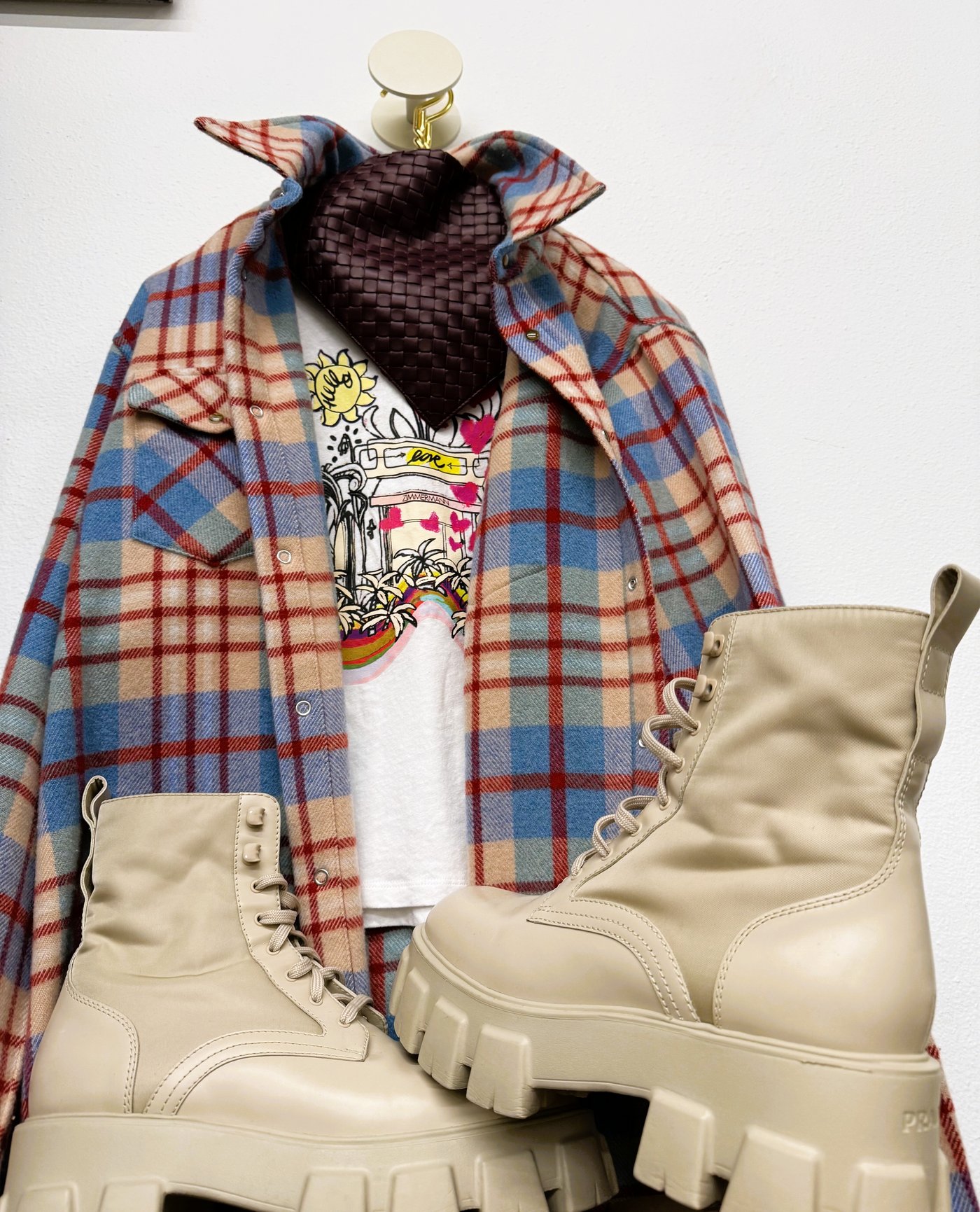 Plaid flannel shirt with a woven Bottega Veneta pouch and Prada platform boots