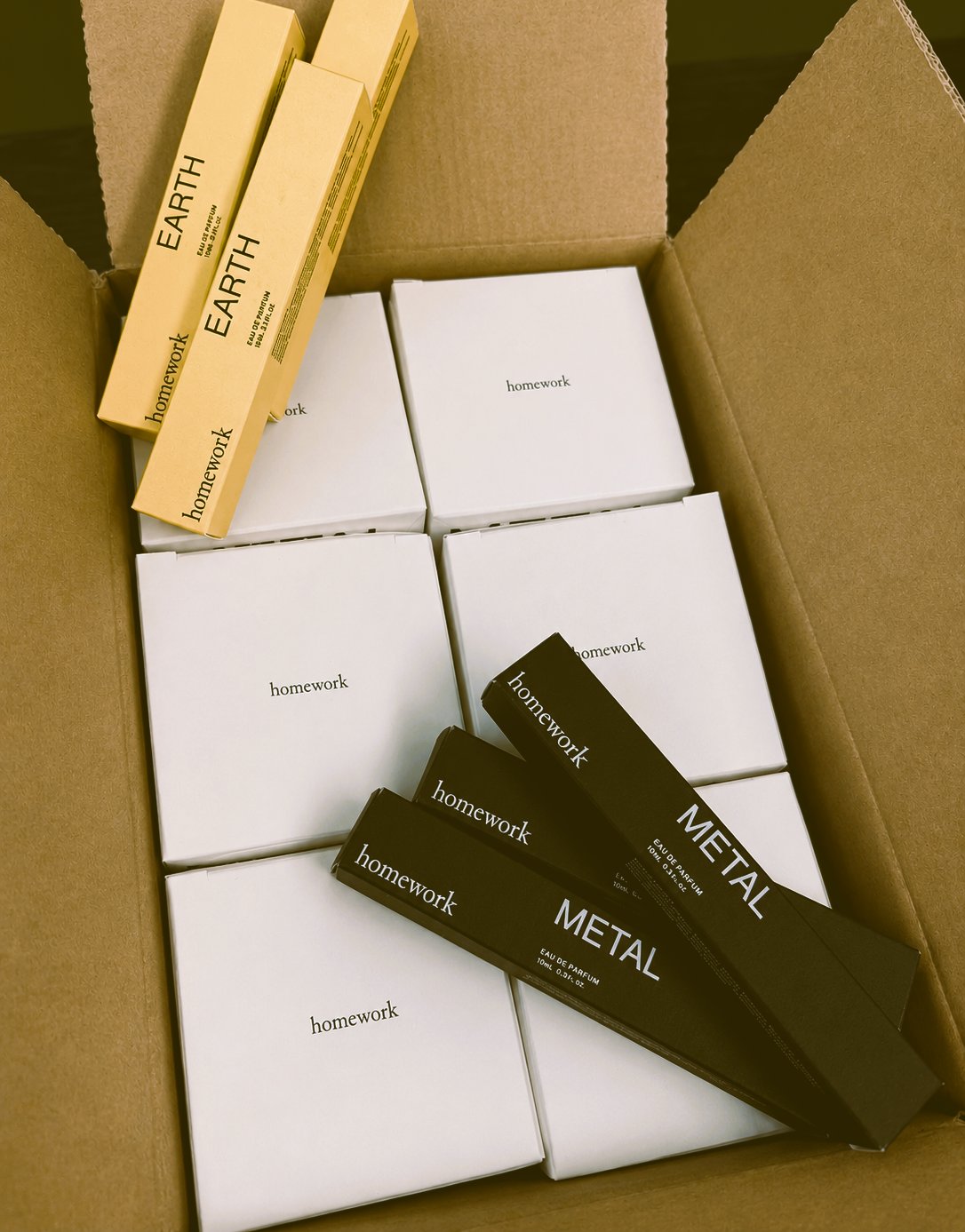 Homework fragrance boxes, Earth and Metal, inside a shipping box