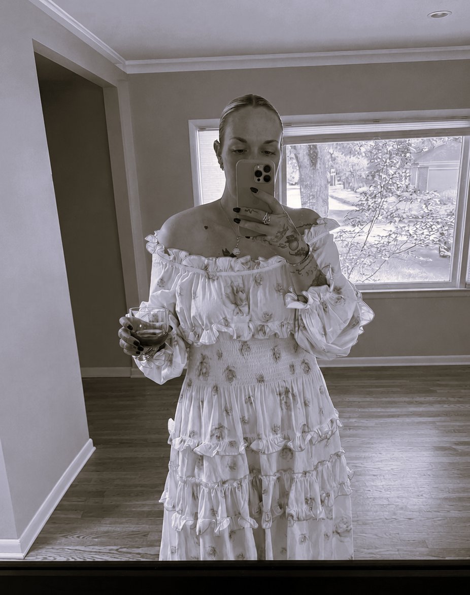 Mirror selfie wearing a ruffled floral off-the-shoulder dress