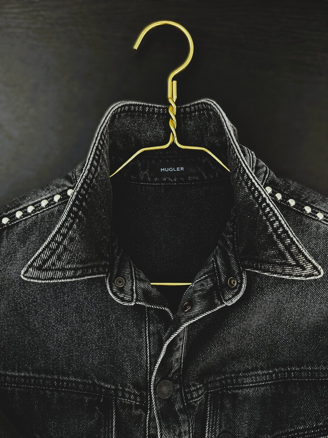 Black Mugler denim jacket collar on a gold hanger