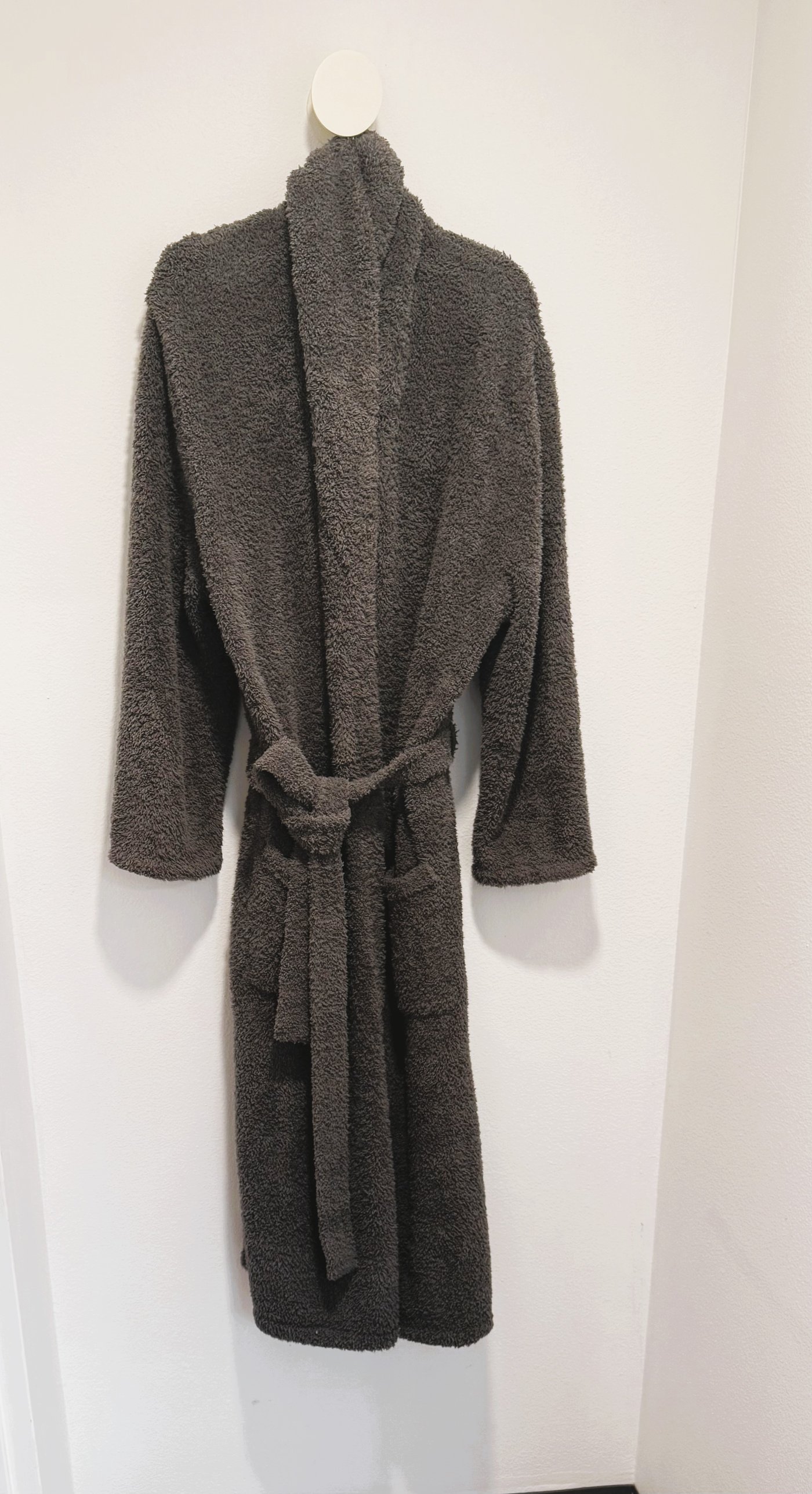 Grey plush robe hanging on a wall hook